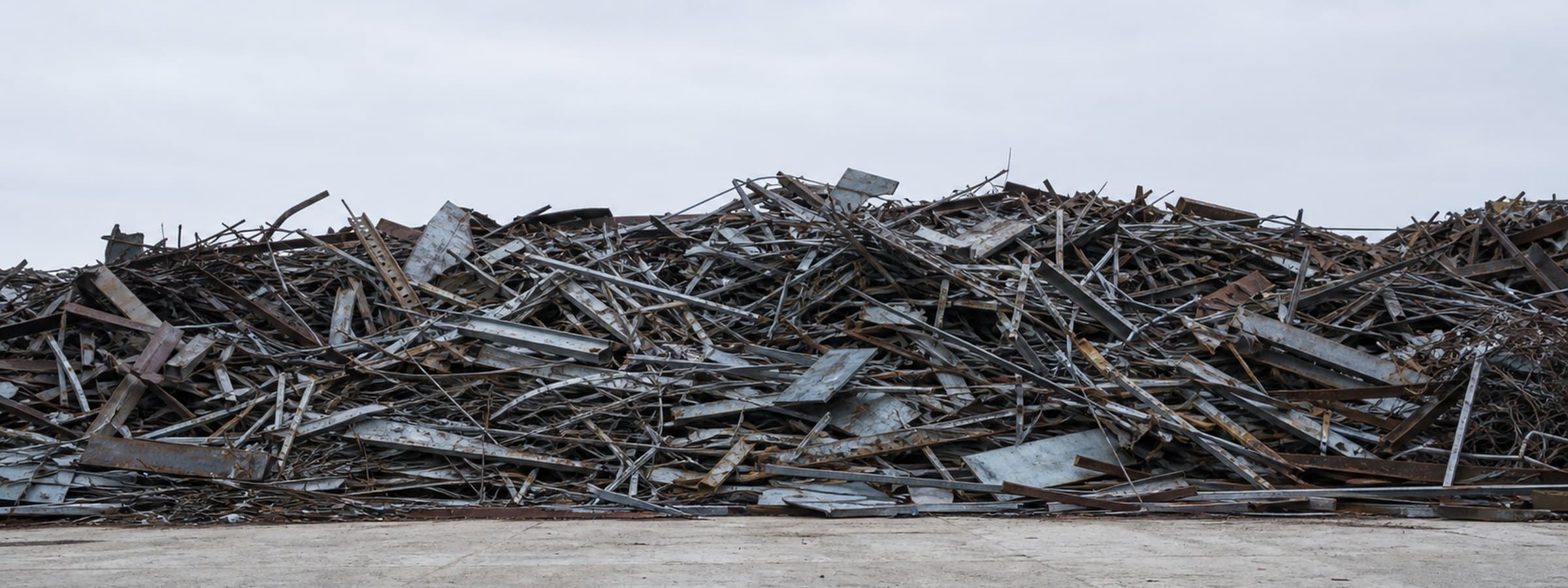 A large pile of mixed steel scrap on a concrete hardstand